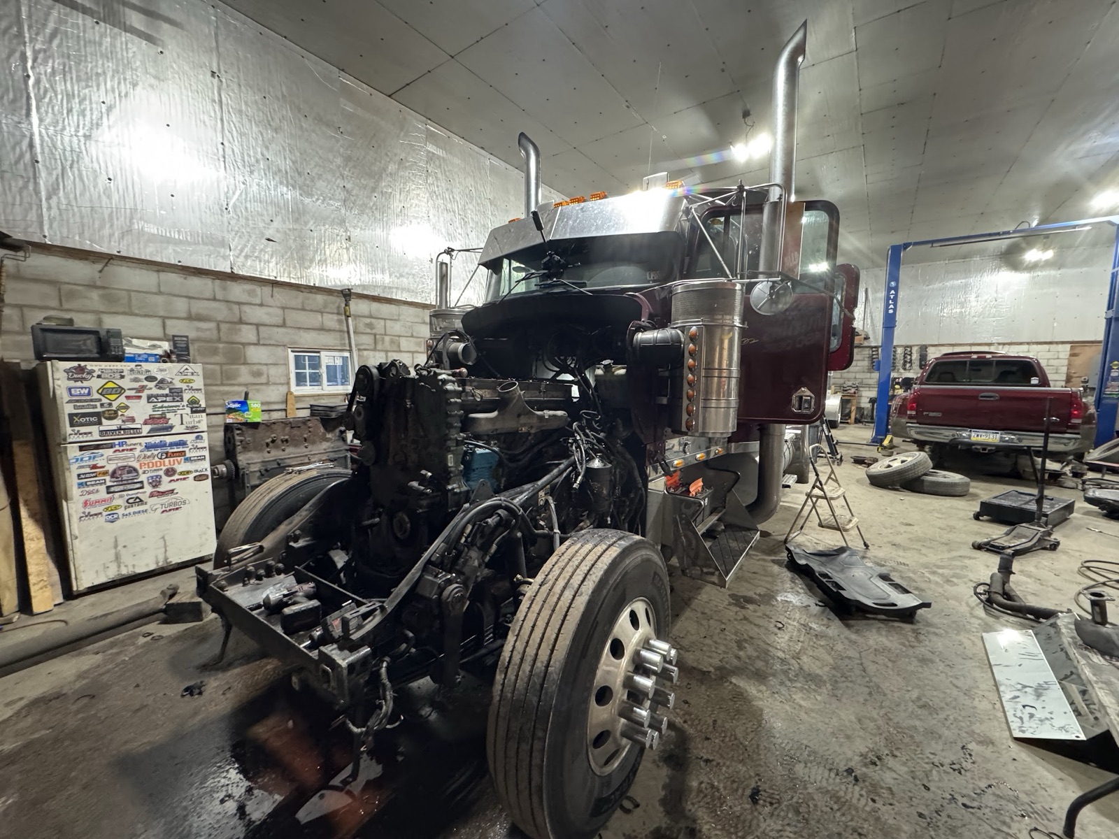 Maroon Peterbilt mid-teardown in the shop